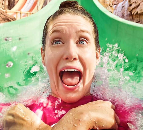 Person enjoying a water slide at Yas Waterworld, Abu Dhabi.