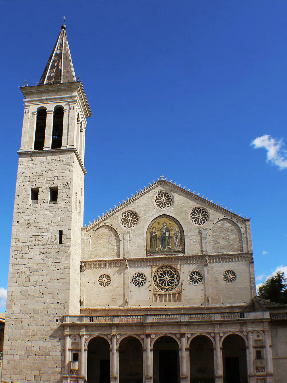 Spoleto Cathedral facade with bell tower under clear blue sky.