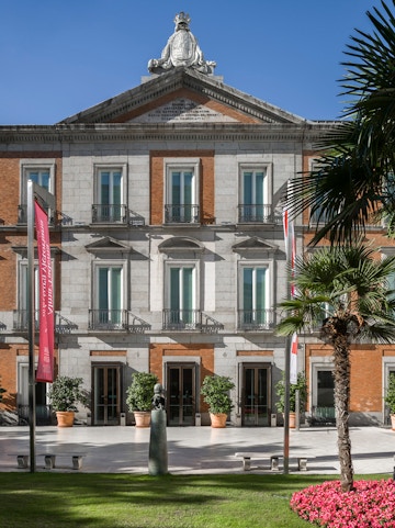 Thyssen Museum facade in Madrid with sculpture and garden in foreground.