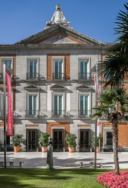 Thyssen Museum facade in Madrid with sculpture and garden in foreground.