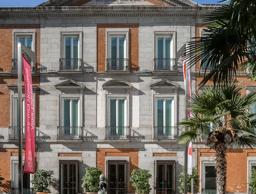 Thyssen Museum facade in Madrid with sculpture and garden in foreground.