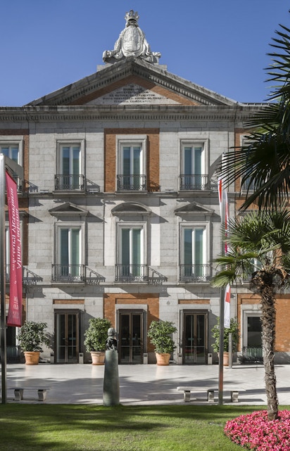 Thyssen Museum facade in Madrid with sculpture and garden in foreground.