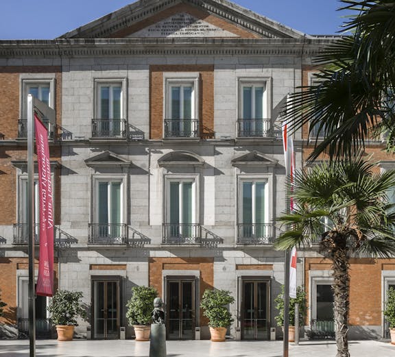 Thyssen Museum facade in Madrid with sculpture and garden in foreground.