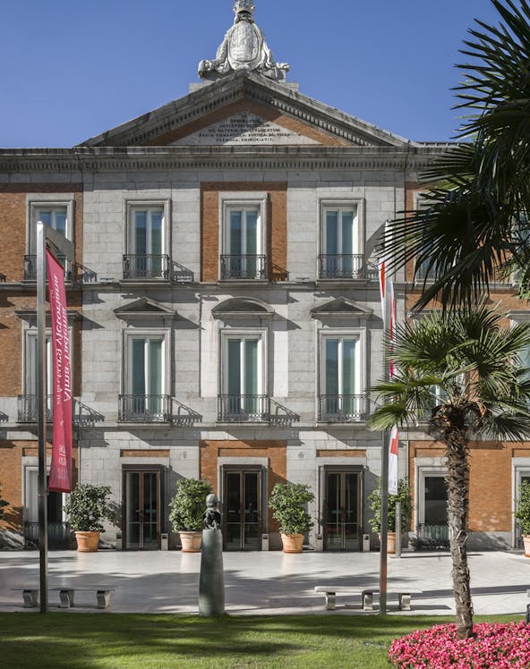 Thyssen Museum facade in Madrid with sculpture and garden in foreground.
