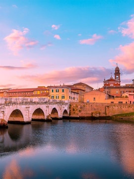 Tiberius Bridge over the Marecchia River at sunset in Rimini, Italy.