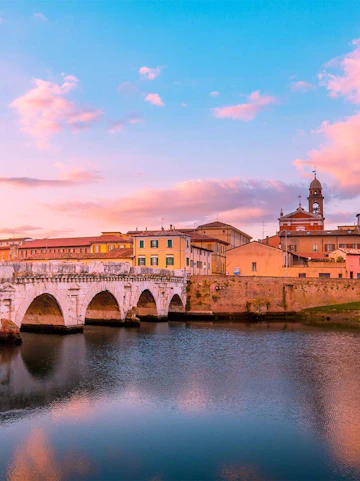 Tiberius Bridge over the Marecchia River at sunset in Rimini, Italy.