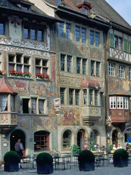 Colorful frescoed buildings in Stein am Rhein, Switzerland, with outdoor café tables.