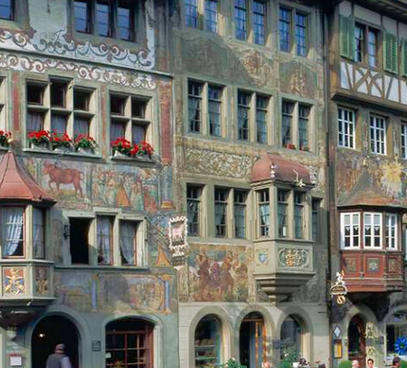 Colorful frescoed buildings in Stein am Rhein, Switzerland, with outdoor café tables.