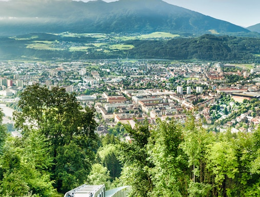 Funicular ascending Nordkette mountain with Innsbruck cityscape in the background.