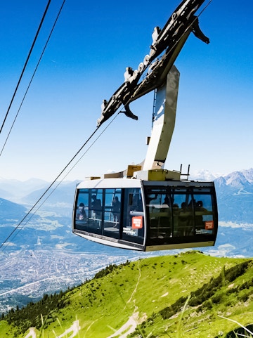 Hungerburg Funicular ascending over Innsbruck with mountain views.