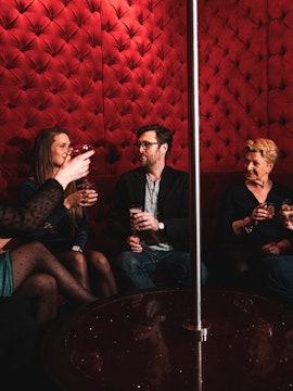 Group enjoying drinks in a red velvet lounge on the Tour de Bonton.