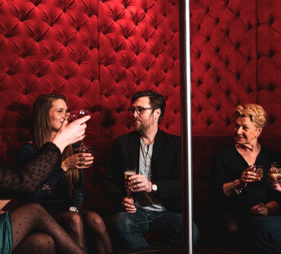 Group enjoying drinks in a red velvet lounge on the Tour de Bonton.