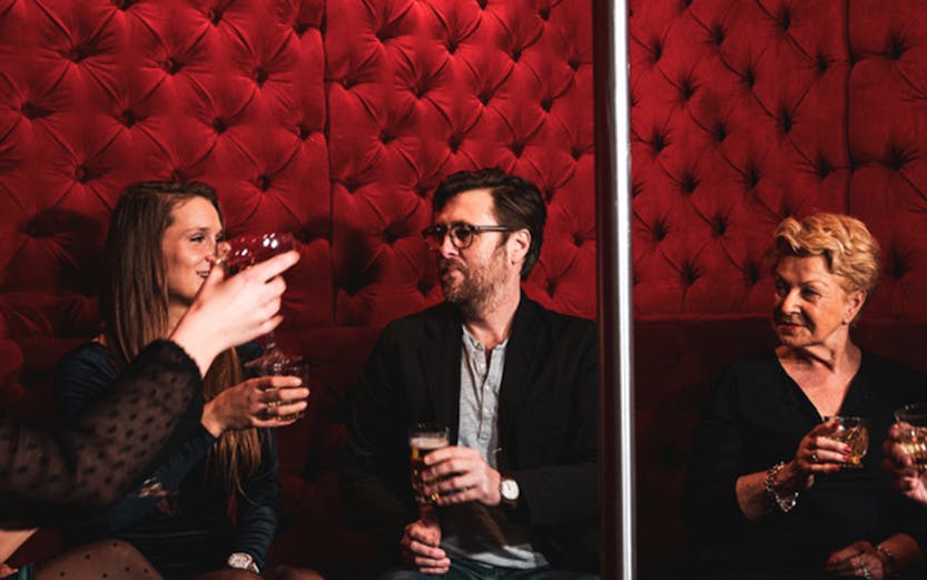 Group enjoying drinks in a red velvet lounge on the Tour de Bonton.