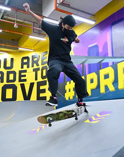 Skateboarder performing trick at SuperPark Singapore indoor skate area.