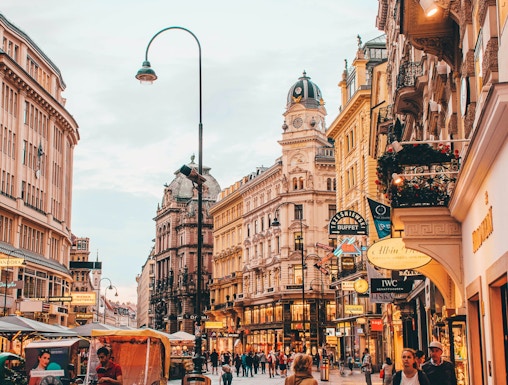 Vienna city street near Sigmund Freud Museum with people and historic buildings.