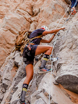 Climber ascending rocky terrain at Bear Grylls Explorers Camp.