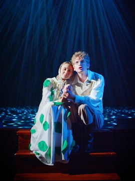 Couple sitting on stage during a romantic West End show performance.