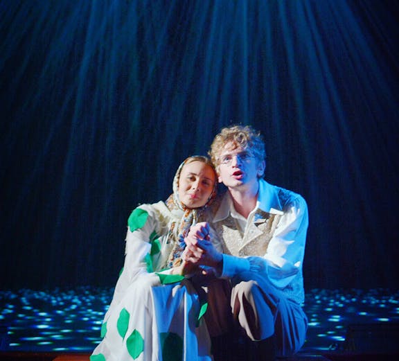 Couple sitting on stage during a romantic West End show performance.