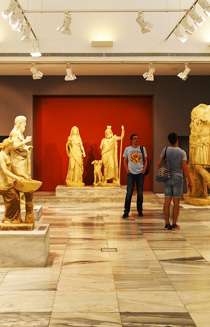 Heraklion Archeological Museum interior with ancient Greek statues on display.