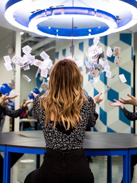 Person interacting with floating cards exhibit at Museum of Illusions.
