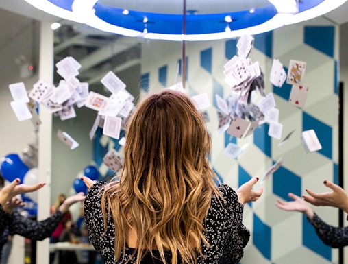 Person interacting with floating cards exhibit at Museum of Illusions.