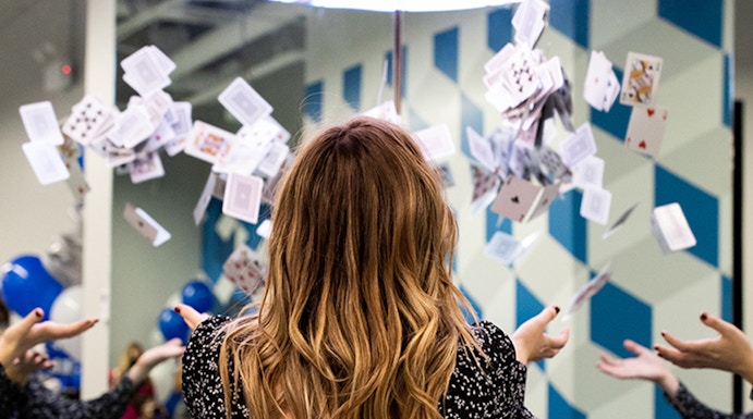 Person interacting with floating cards exhibit at Museum of Illusions.