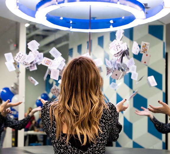 Person interacting with floating cards exhibit at Museum of Illusions.