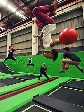 People playing dodgeball on trampolines at Jump Street Asia indoor park.