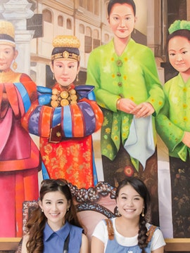 Visitors posing with vibrant cultural murals at MagicArt 3D Museum, Melaka.