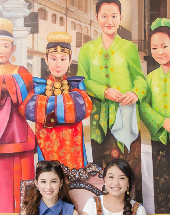 Visitors posing with vibrant cultural murals at MagicArt 3D Museum, Melaka.