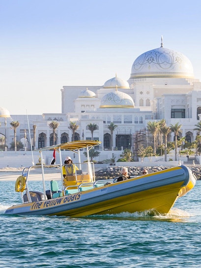Yellow boat cruising near Qasr Al Watan, Abu Dhabi.