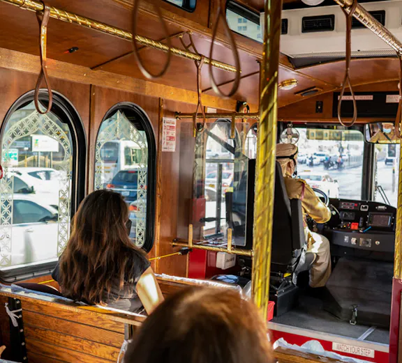 Inside view of Heritage Express tour bus in Dubai with passengers seated.