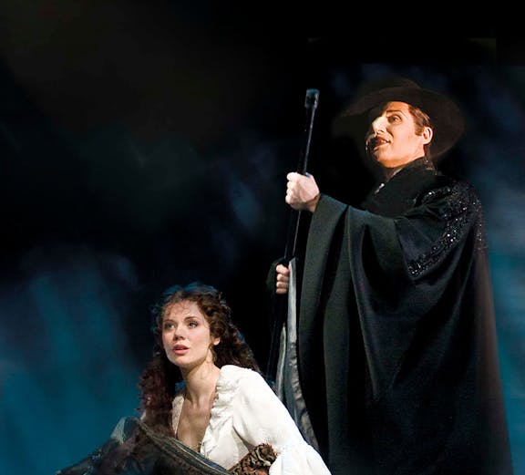 Two performers in a dramatic scene from a classic theater show.