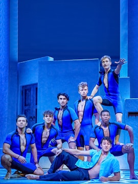 Performers in blue costumes on stage during a jukebox musical.