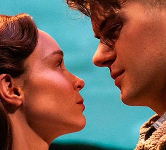 Actors in an intimate scene from a romantic Broadway show.