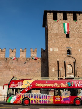 City Sightseeing Verona bus in front of historic Verona building.