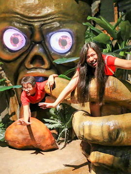 Visitors interacting with a giant monster display at Ghost Museum Melaka.