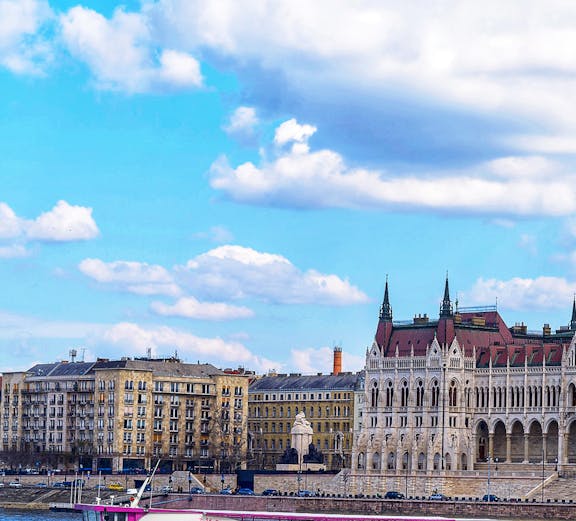 Sightseeing boat on the Danube River with Budapest Parliament in the background.