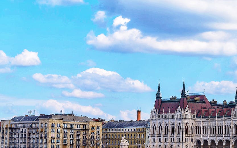 Sightseeing boat on the Danube River with Budapest Parliament in the background.