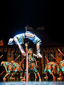 Performers in traditional costumes during Devdan Show, Bali, executing a dramatic acrobatic act.