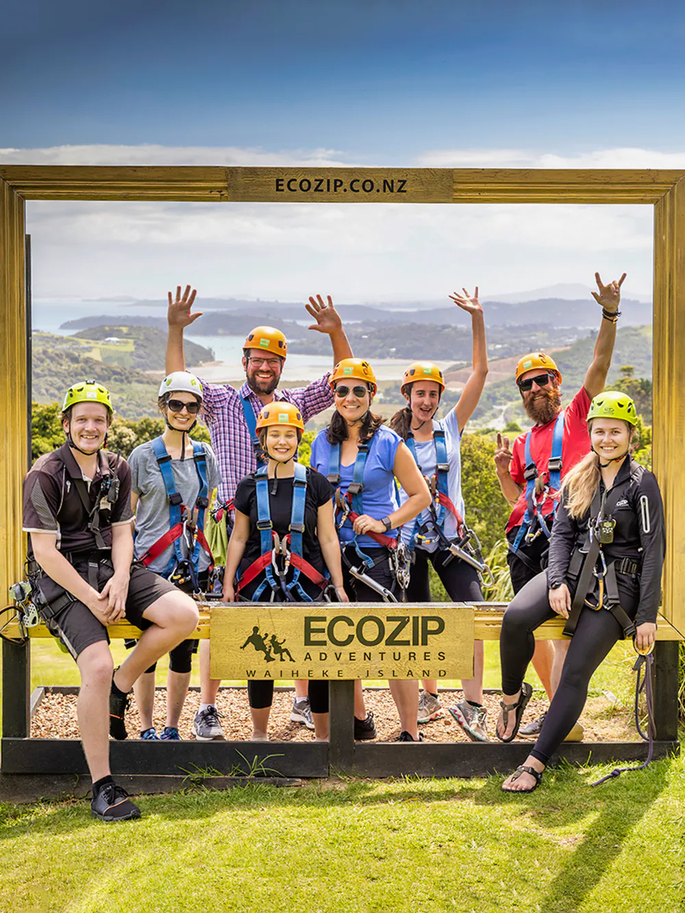 Group of people in harnesses at EcoZip Adventures, Waiheke Island, with scenic view.