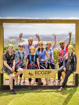 Group of people in harnesses at EcoZip Adventures, Waiheke Island, with scenic view.