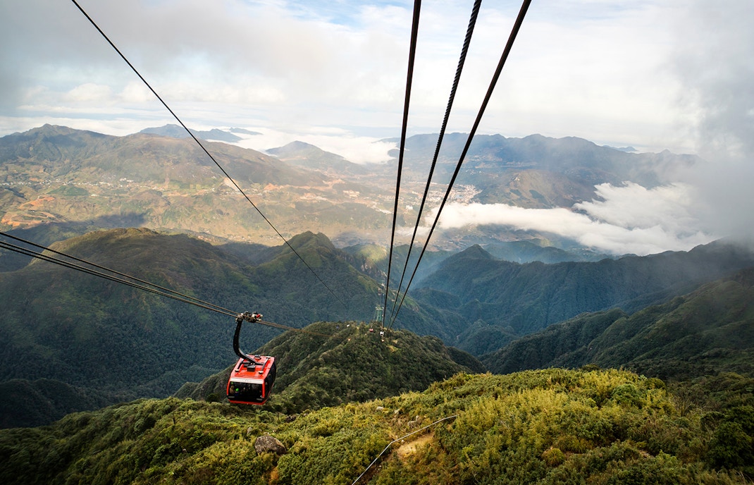 Cable car ascending over lush mountains at Sun World Ba Na Hills, Vietnam.
