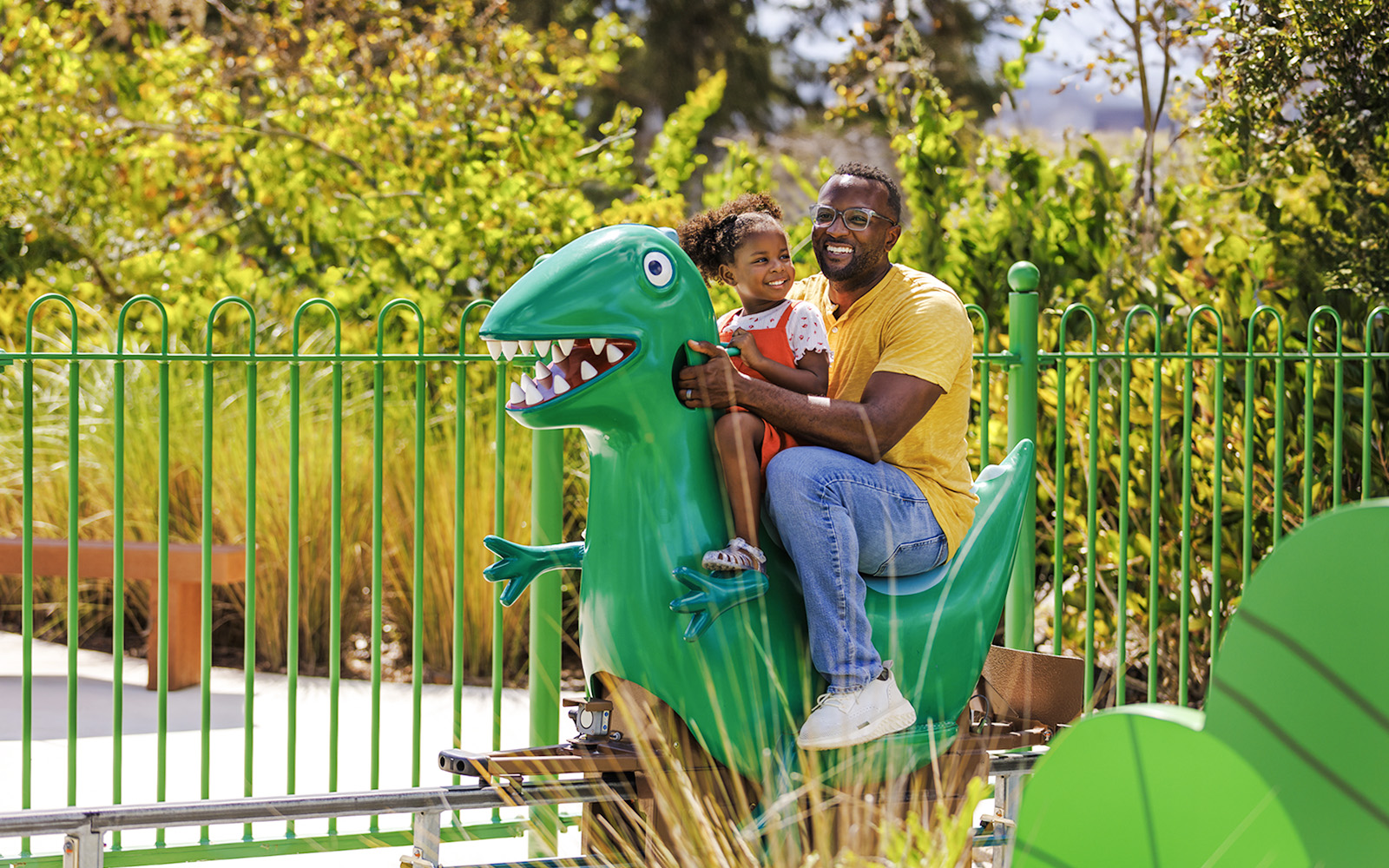 Father and child on dinosaur ride at Peppa Pig Theme Park, Florida.