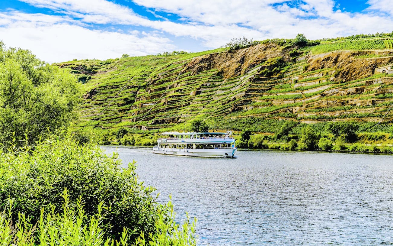 Gilles boat cruising along the Middle Rhine Valley with terraced vineyards in the background.