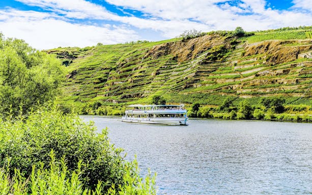 Gilles boat cruising along the Middle Rhine Valley with terraced vineyards in the background.