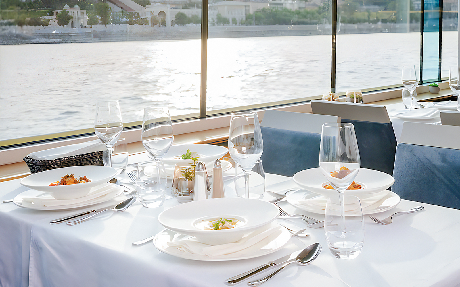 Dinner table set on Danube cruise in Budapest with river view.
