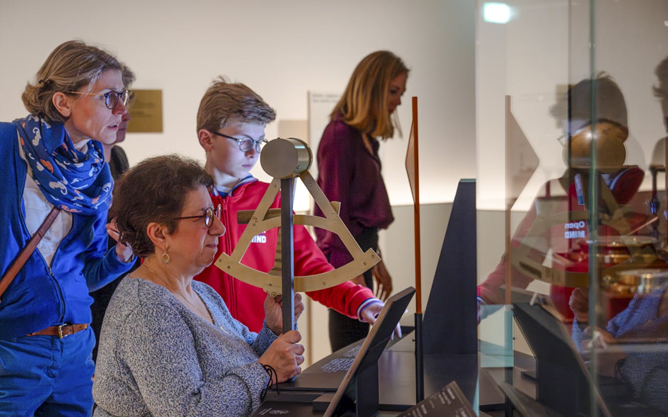 Visitors engaging with an interactive exhibit at the National Marine Museum, Paris, France.