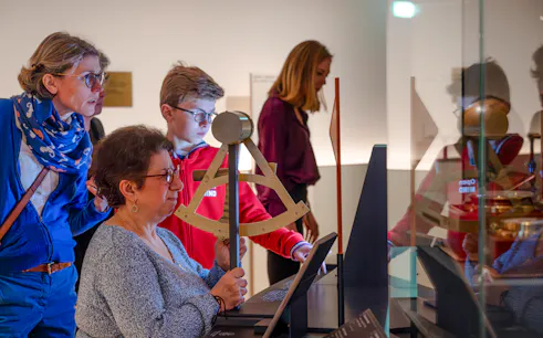 Visitors engaging with an interactive exhibit at the National Marine Museum, Paris, France.