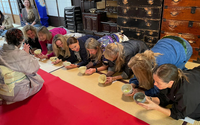 Tourists participating in a traditional tea ceremony in a Kyoto tea room.
